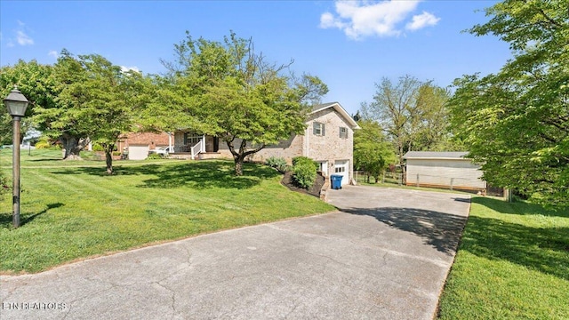 view of front of home featuring a garage, driveway, and a front yard
