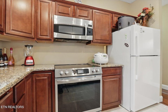 12116 W Kings Gate Rd, Farragut, TN 37934 - kitchen with appliances with stainless steel finishes, light stone countertops, and brown cabinetry