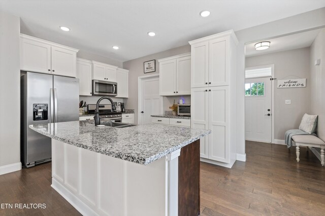 kitchen featuring appliances with stainless steel finishes, dark wood-style floors, baseboards, white cabinetry, and recessed lighting