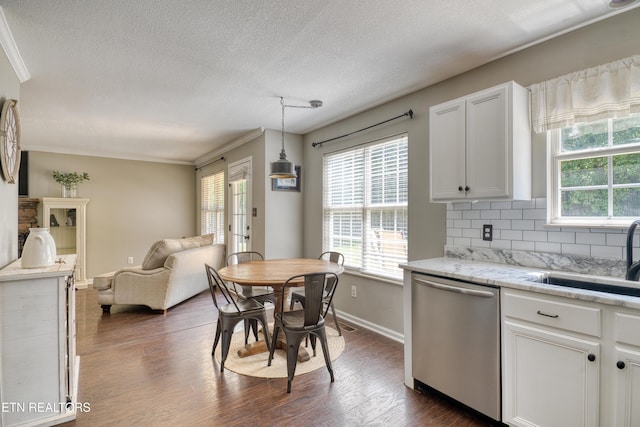 kitchen with stainless steel dishwasher, a sink, a wealth of natural light, and open floor plan