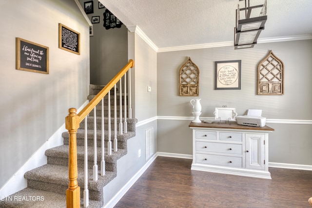 staircase featuring crown molding, a textured ceiling, baseboards, and wood finished floors