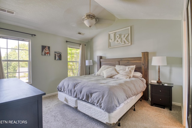 bedroom with baseboards, light colored carpet, lofted ceiling, and visible vents