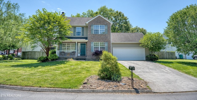 view of front of home with concrete driveway, fence, a front yard, and a garage