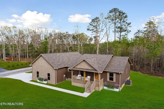 view of front of house featuring a porch, a shingled roof, a front lawn, and cooling unit