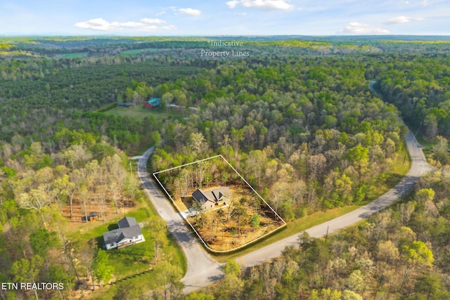 birds eye view of property with a view of trees