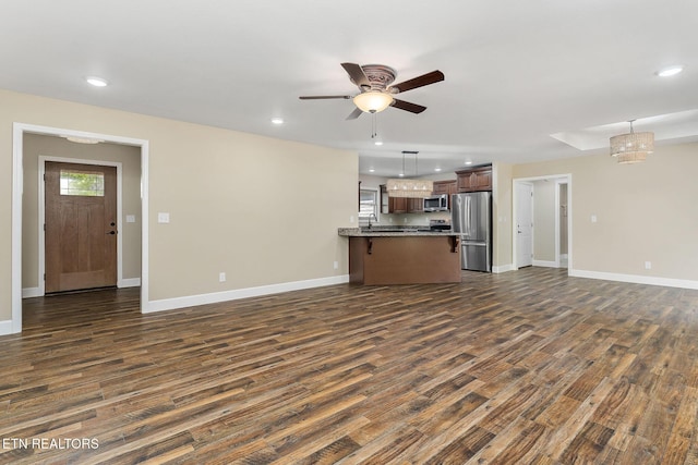 unfurnished living room featuring baseboards, a ceiling fan, dark wood finished floors, and recessed lighting