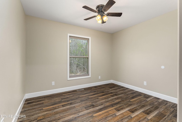 spare room featuring baseboards, a ceiling fan, and dark wood-type flooring