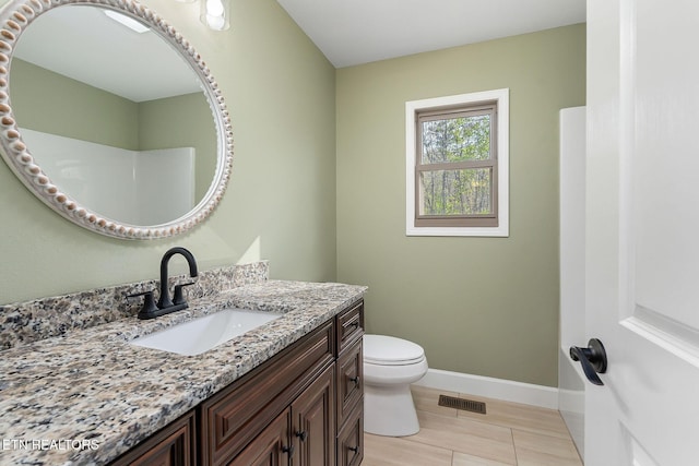 bathroom featuring baseboards, vanity, toilet, and visible vents