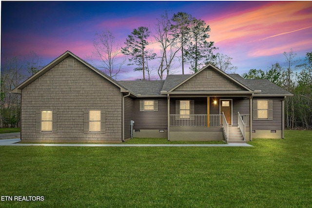 view of front of property featuring roof with shingles, a yard, covered porch, and crawl space