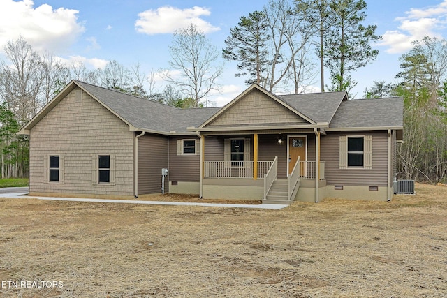 view of front of property with covered porch, a shingled roof, cooling unit, and crawl space