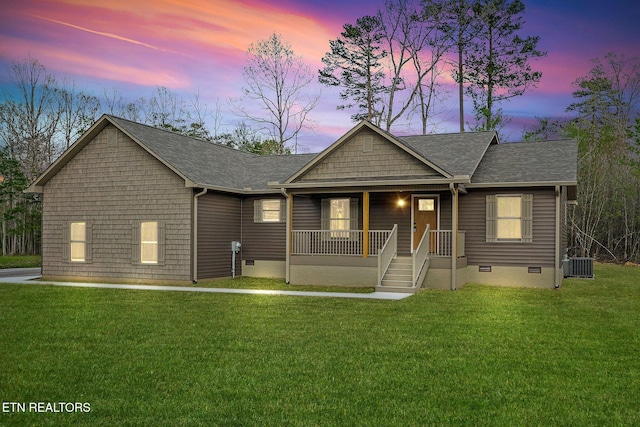view of front of home with roof with shingles, a front lawn, a porch, crawl space, and cooling unit