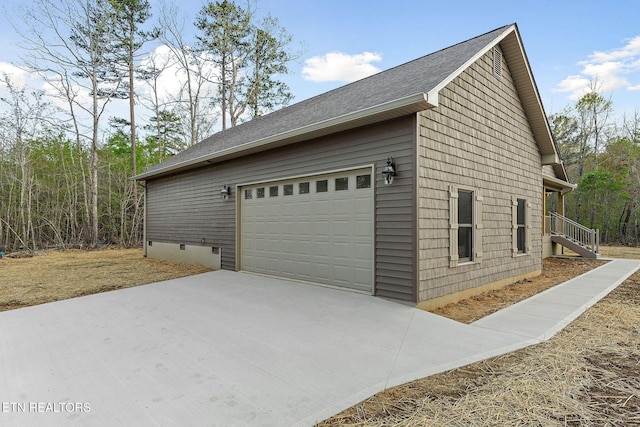 view of side of home with a garage, a shingled roof, driveway, and crawl space