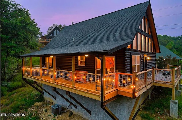 back of property featuring roof with shingles, log siding, central AC unit, and a wooden deck