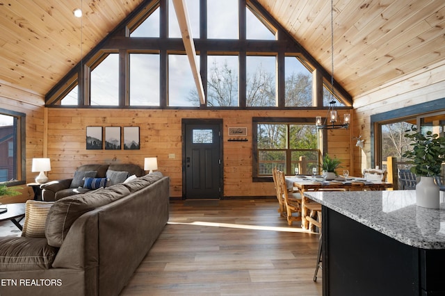 living room featuring a healthy amount of sunlight, wooden ceiling, wood walls, and high vaulted ceiling