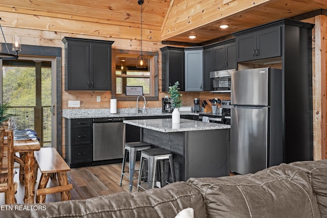 kitchen with light stone counters, open floor plan, dark wood-style flooring, and appliances with stainless steel finishes