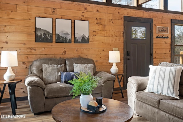 living area featuring wood walls and wood finished floors