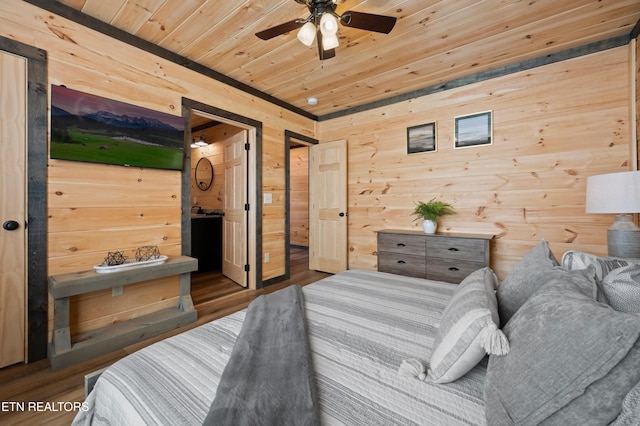 bedroom featuring wood ceiling, ensuite bath, wood walls, and wood finished floors