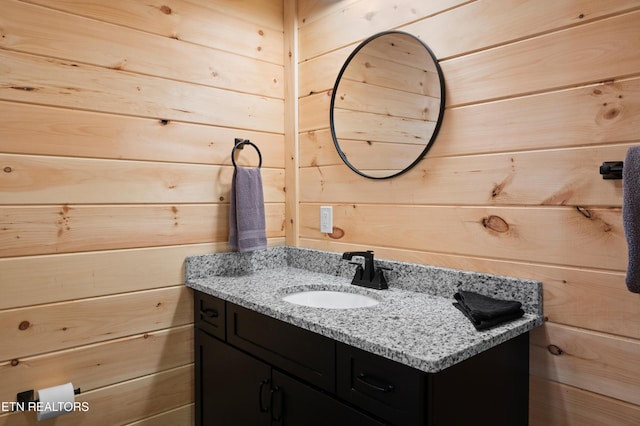 bathroom featuring wooden walls and vanity
