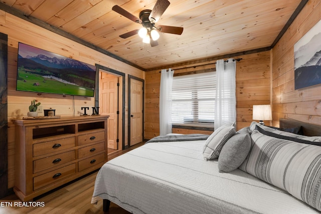 bedroom with wooden walls, a ceiling fan, wood ceiling, and wood finished floors