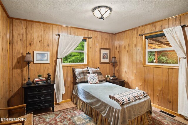 3009 Winding Way, Cosby, TN 37722 - bedroom featuring wood walls, wood finished floors, crown molding, and a textured ceiling