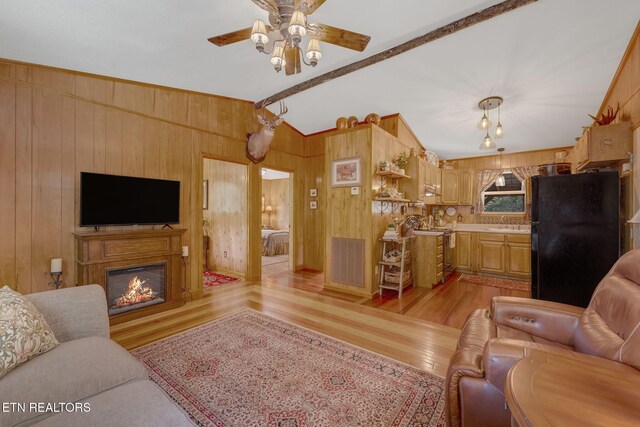 3009 Winding Way, Cosby, TN 37722 - living room featuring light wood-type flooring, a ceiling fan, a glass covered fireplace, wood walls, and lofted ceiling