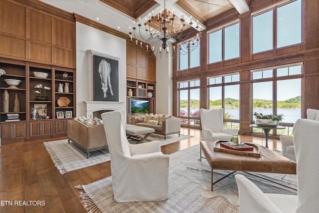 interior space with dark wood-style flooring, a towering ceiling, beamed ceiling, a chandelier, and coffered ceiling