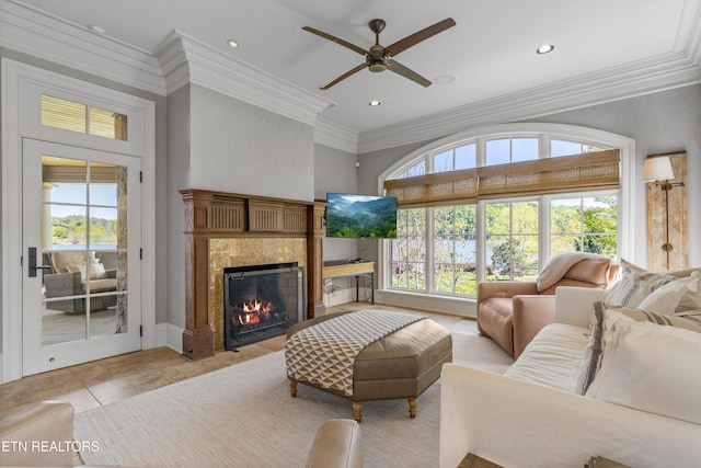 living room featuring plenty of natural light, a ceiling fan, crown molding, and a premium fireplace