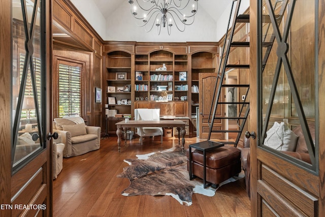 sitting room with an inviting chandelier, high vaulted ceiling, wooden walls, and hardwood / wood-style floors