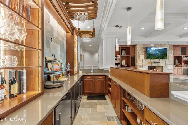 bar featuring pendant lighting, ornamental molding, a sink, and stone tile flooring