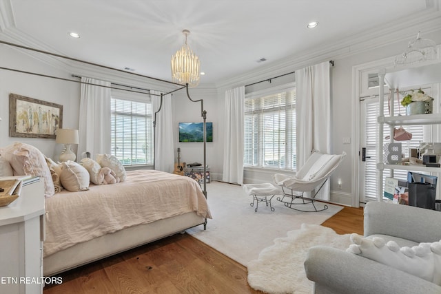 bedroom featuring crown molding, multiple windows, wood finished floors, and a chandelier
