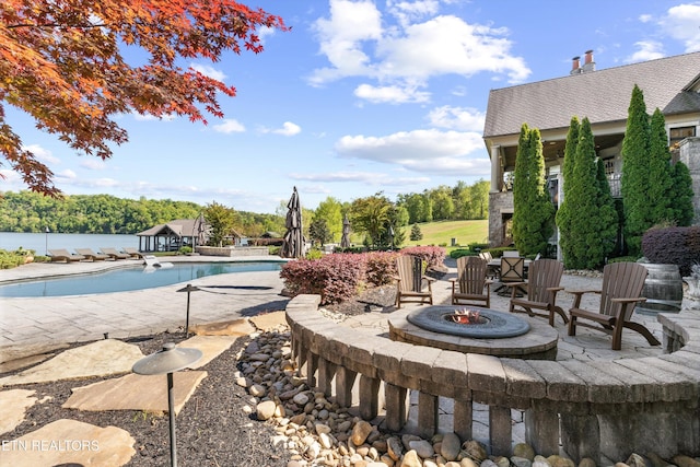 view of pool featuring a fenced in pool, an outdoor fire pit, and a patio area
