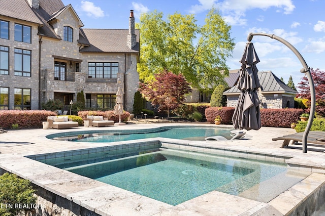 view of pool with a patio and an in ground hot tub
