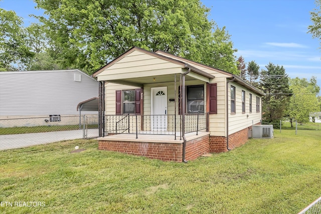 view of front facade with covered porch, a carport, central air condition unit, fence, and a front lawn
