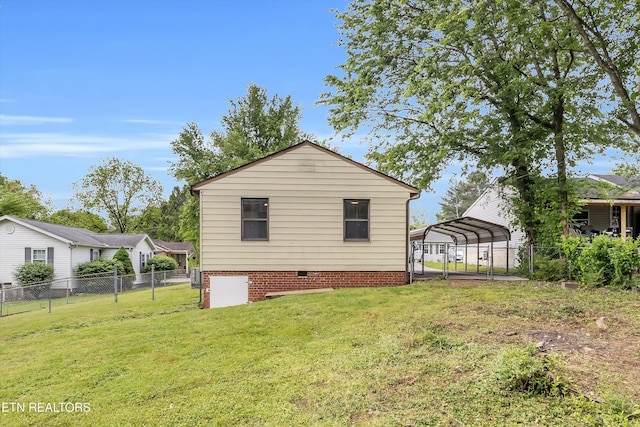 rear view of property with fence, a carport, a yard, and crawl space