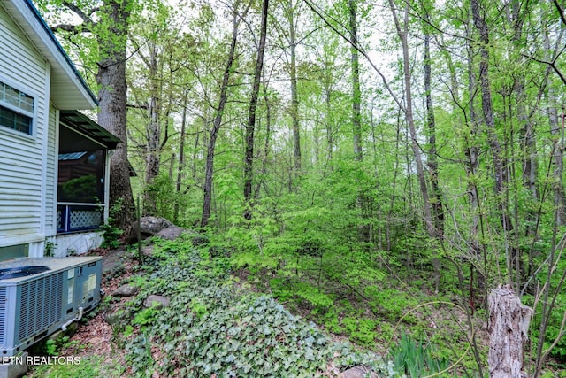 5355 E Pkwy, Cosby, TN 37722 - view of yard featuring a sunroom, central air condition unit, and a forest view