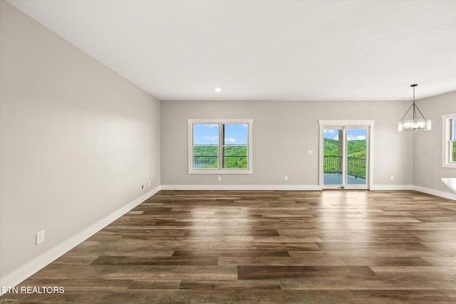 448 Taylor Rd, Byrdstown, TN 38549 - unfurnished room with an inviting chandelier, dark wood-style flooring, and a healthy amount of sunlight