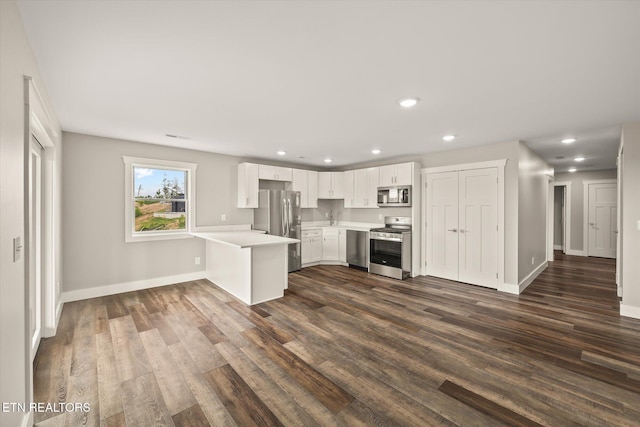 448 Taylor Rd, Byrdstown, TN 38549 - kitchen with appliances with stainless steel finishes, light countertops, a sink, white cabinets, and a peninsula