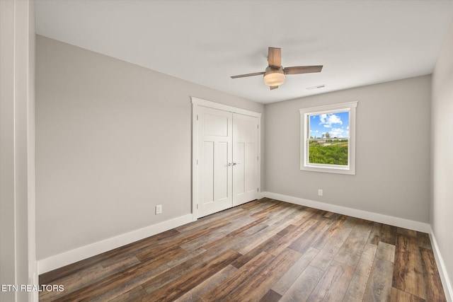 448 Taylor Rd, Byrdstown, TN 38549 - unfurnished bedroom with ceiling fan, visible vents, wood finished floors, baseboards, and a closet