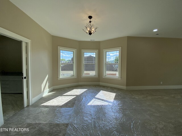 unfurnished dining area featuring baseboards, carpet, and a chandelier