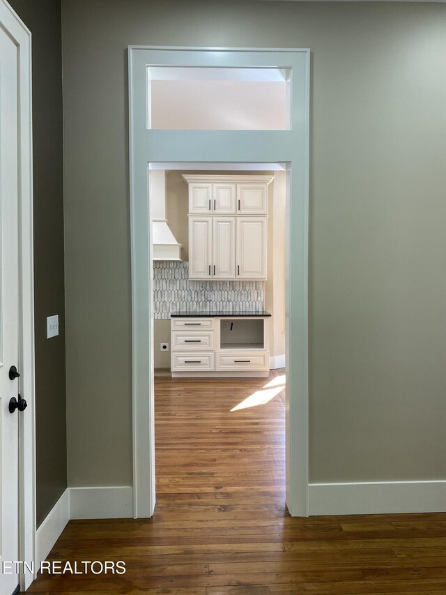 hall featuring baseboards and wood finished floors