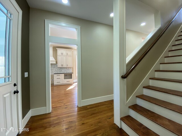 staircase with recessed lighting, baseboards, and wood finished floors