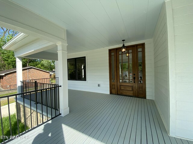 view of exterior entry with a carport and a porch