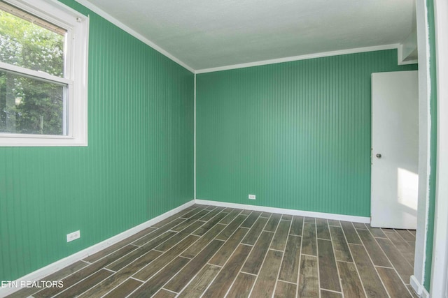 empty room with crown molding, baseboards, and dark wood-style floors