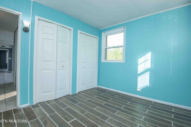 unfurnished bedroom featuring baseboards and wood finish floors