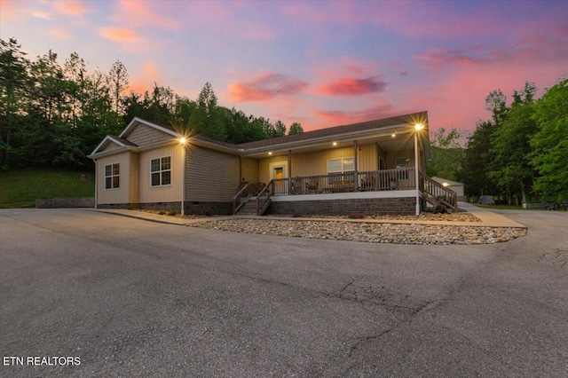 view of front of home with a porch, stairway, and crawl space