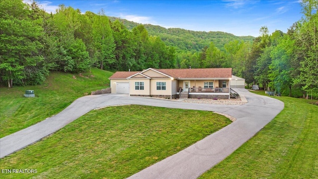 mediterranean / spanish-style home featuring a porch, a view of trees, an attached garage, and a front lawn