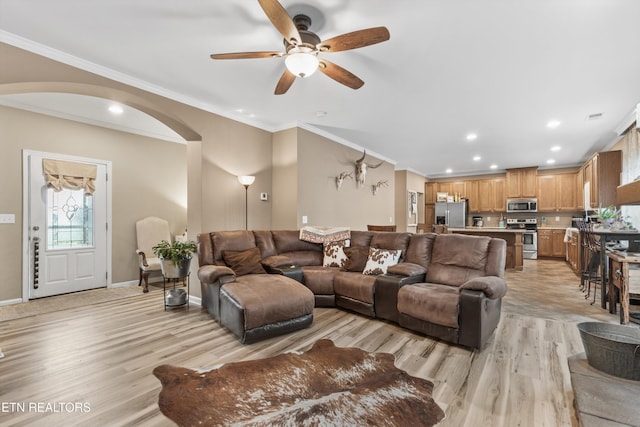 living area featuring ceiling fan, crown molding, arched walkways, recessed lighting, and light wood-style flooring