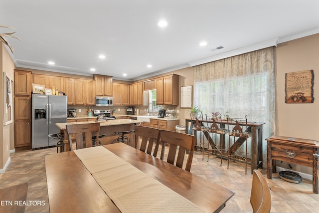 dining area with stone finish flooring, recessed lighting, visible vents, and ornamental molding
