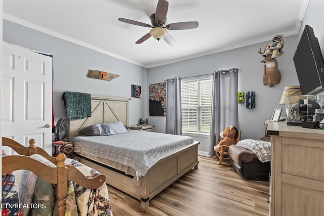 bedroom featuring light wood-type flooring, ornamental molding, and a ceiling fan