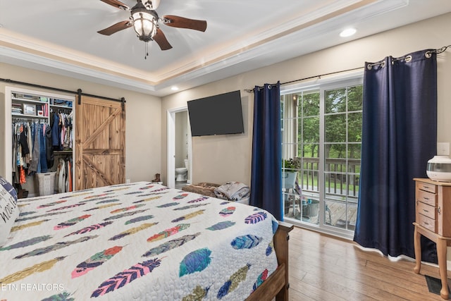 bedroom featuring access to outside, recessed lighting, a barn door, and hardwood / wood-style floors